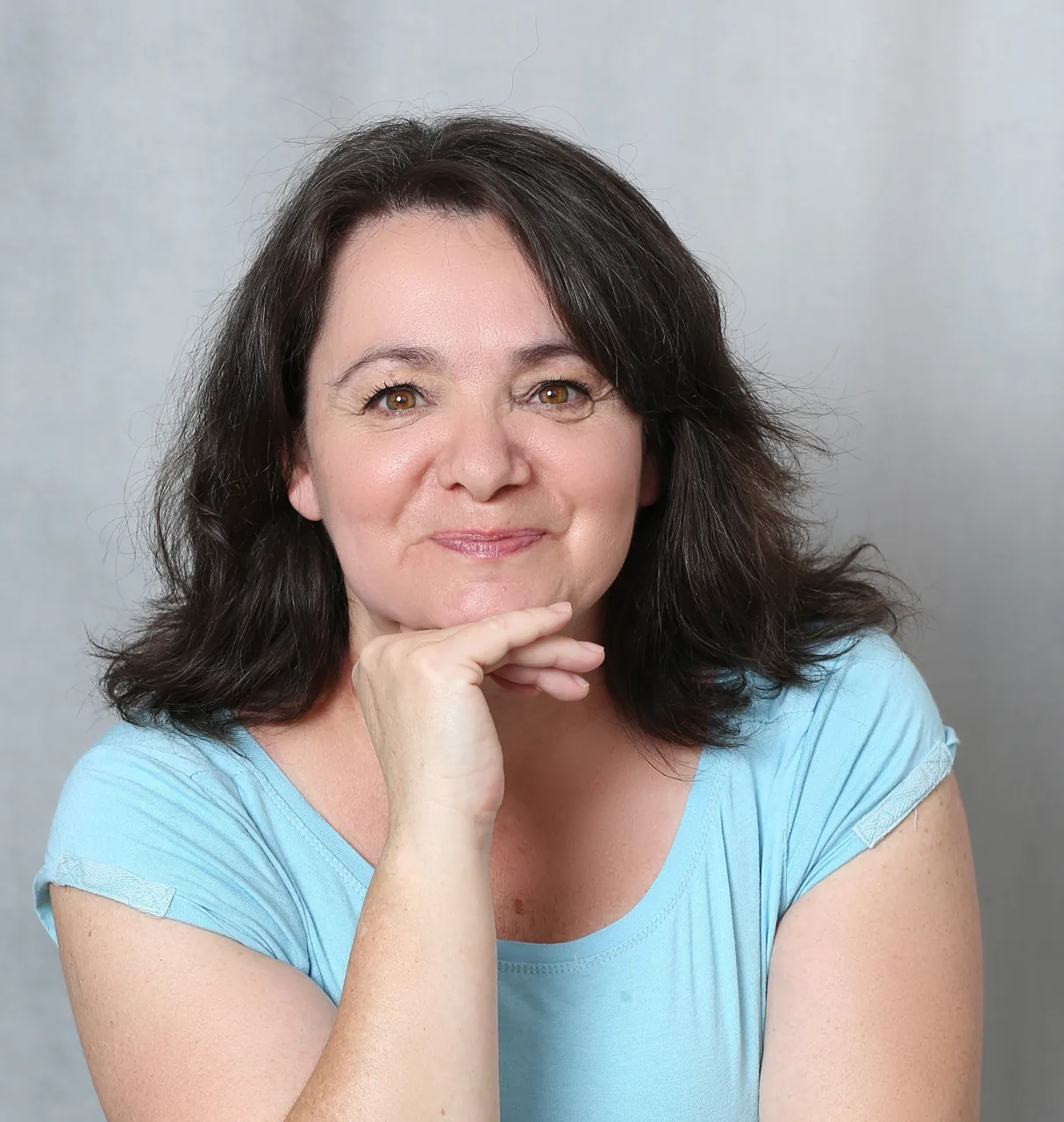 Somogyi Eszter mosolyogva, állát a kezén nyugtatva